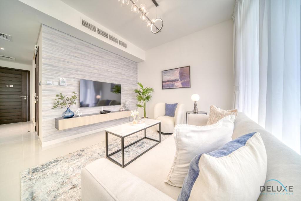 a living room with a white couch and a tv at Cheerful 3BR Townhouse at DAMAC Hills 2, Dubailand by Deluxe Holiday Homes in Dubai