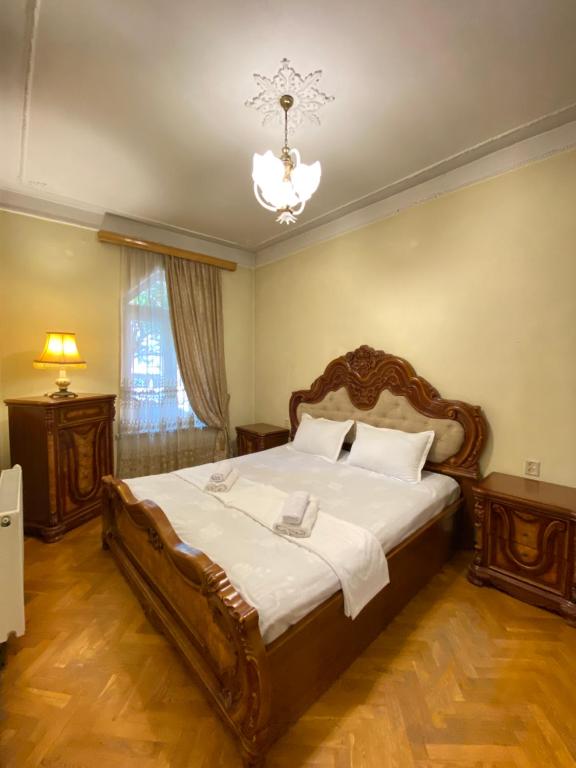 um quarto com uma cama grande e um lustre em Davit's Apartment 21 em Tbilisi