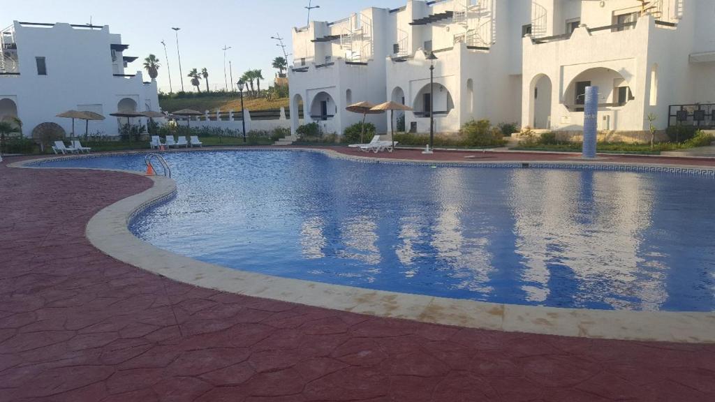 a large swimming pool in front of a building at Magnifique Villa Al Cudia Smir vue Mer Fnideq / Mdiq in Fnidek