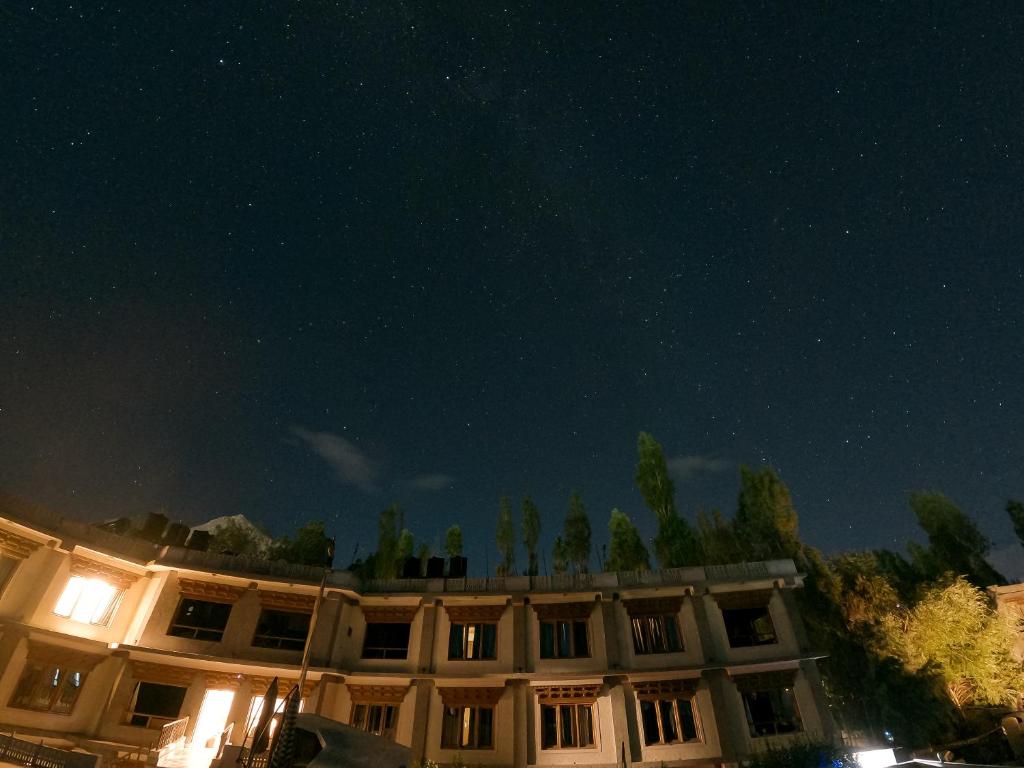 un edificio de noche con las estrellas en el cielo en Cho Palace, en Leh
