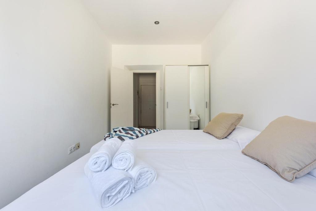 a bedroom with a white bed with towels on it at Apartamento Alborea in Granada