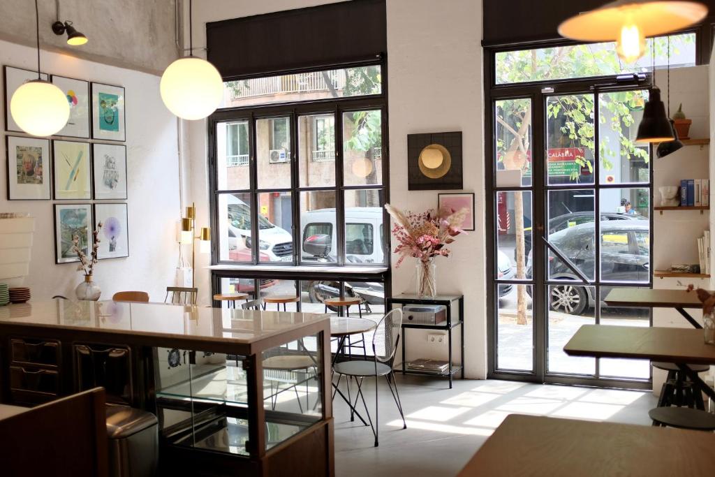 a restaurant with tables and chairs and large windows at Magatzem 128 in Barcelona