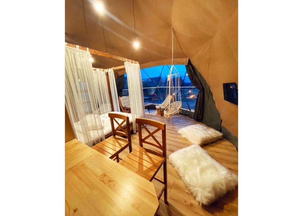 Zimmer mit einem Zelt mit einem Tisch und Stühlen in der Unterkunft Çatı Katı Bungalow & Dome in Çivril