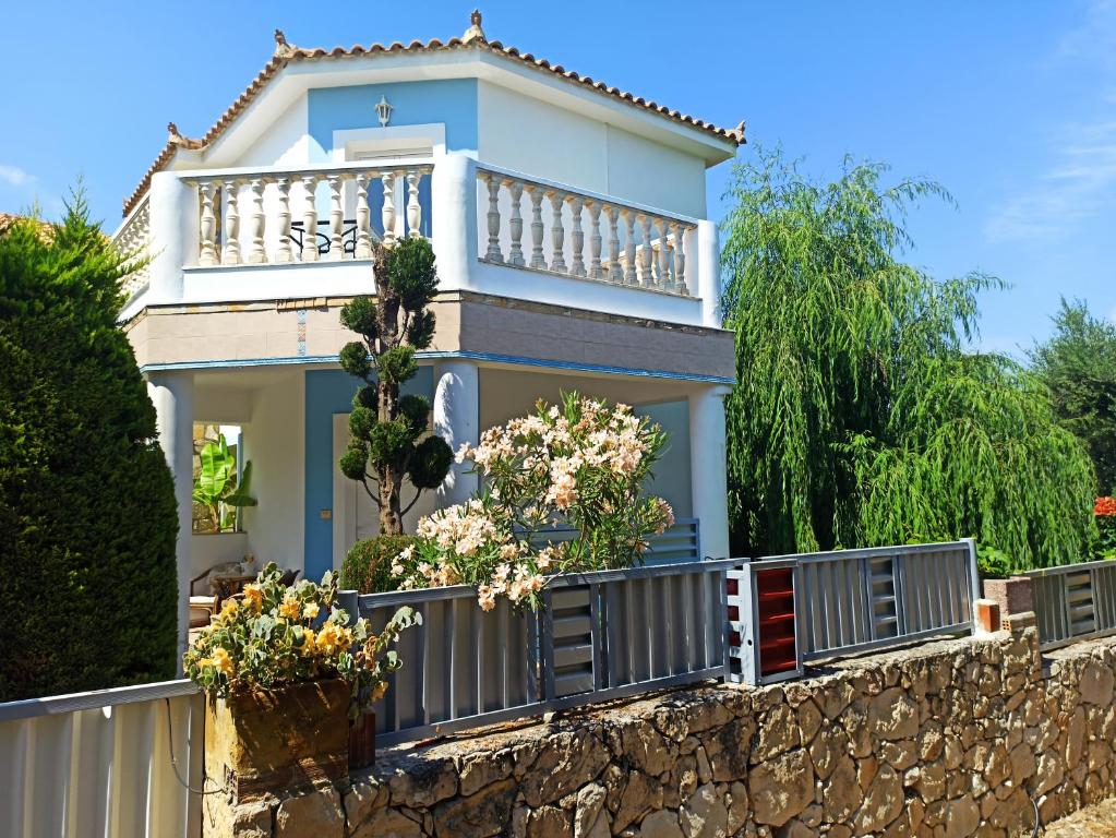 une maison avec un balcon sur un mur en pierre dans l'établissement The Guest house, à Laganas