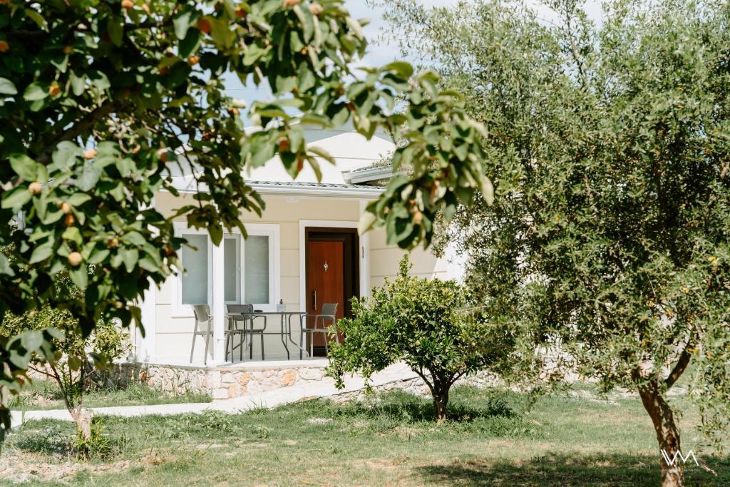 une maison blanche avec des arbres devant elle dans l'établissement Oikies Verde, à Kefalári