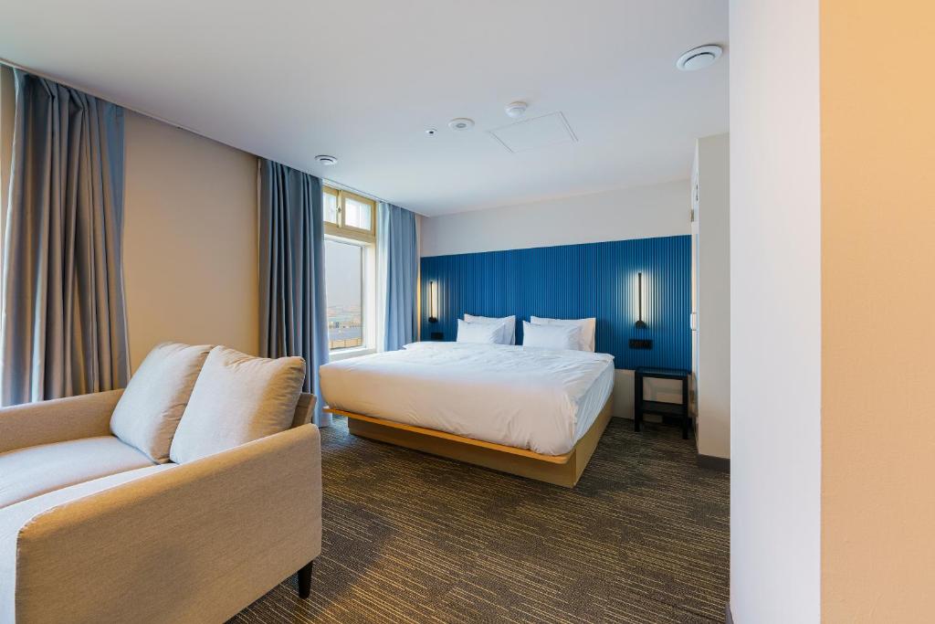 una camera d'albergo con letto e divano di Little Prince Hotel a Gunsan