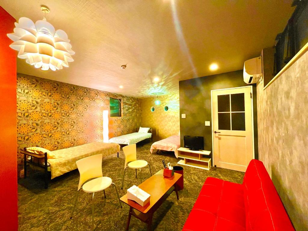 犬山的住宿－ヴィラ犬山，一间带红色沙发的客厅和一间带床的房间