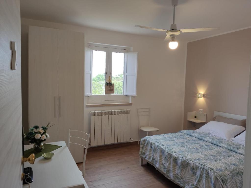 - une chambre avec un lit, une table et une fenêtre dans l'établissement AGRI ART, à San Benedetto Ullano