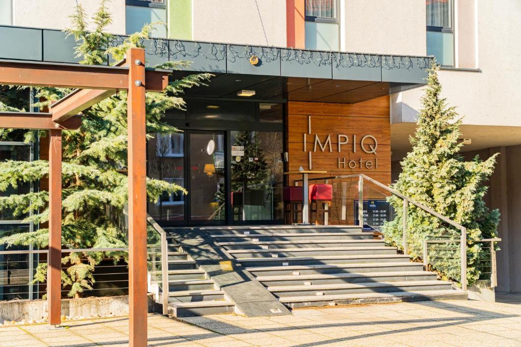 a hotel entrance with stairs in front of a building at IMPIQ Hotel in Trnava