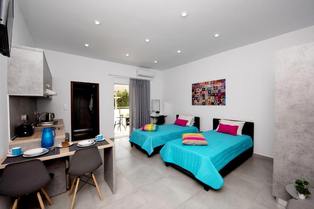 1 dormitorio con 2 camas, mesa y sillas en Maria Studios & Apartments, en Kremasti