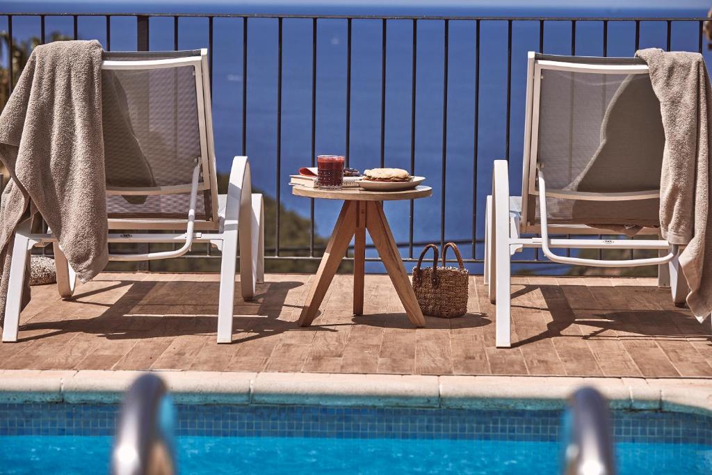 2 sillas y una mesa junto a la piscina en Maristel Hotel & Spa - Adults Only, en Estellencs