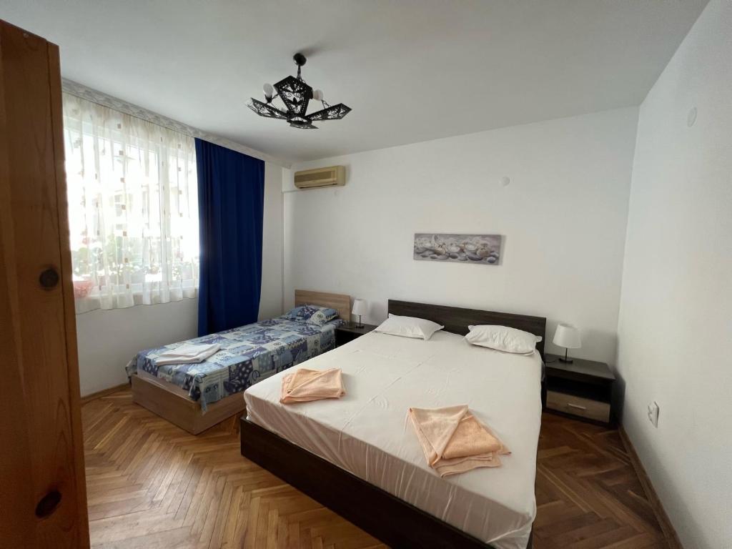 una camera con due letti e un lampadario a braccio di Апартамент Иванови a Pomorie