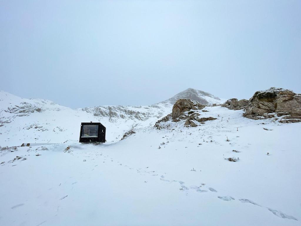 une montagne enneigée avec une boîte au loin dans l'établissement atipic lodge, à Arette