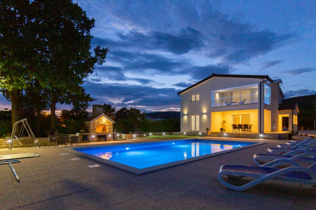 a house with a swimming pool in front of a house at Villa Maria in Donji Proložac