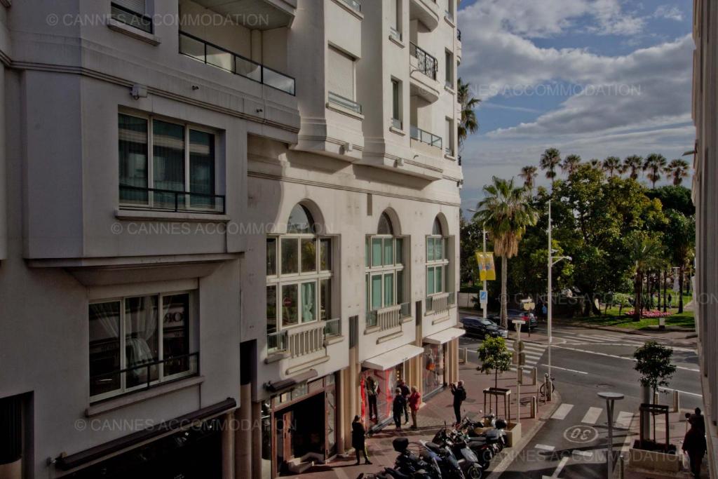 a tall white building with people walking on a street at 7 Croisette 7C201 in Cannes