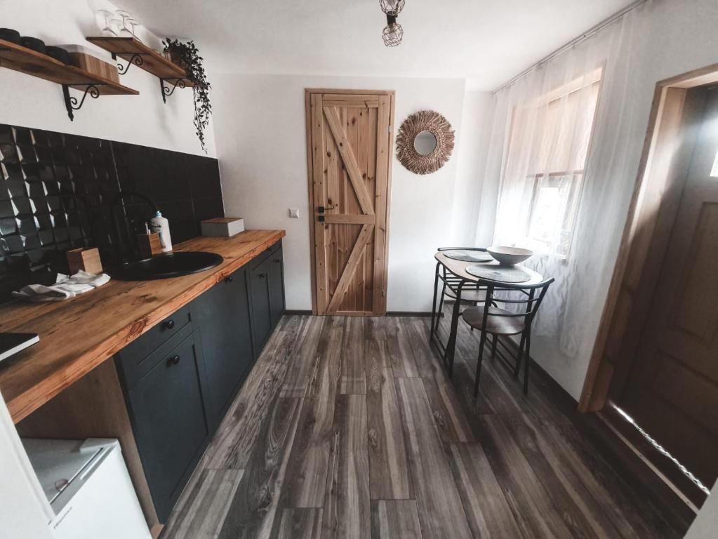 - une cuisine avec un comptoir en bois et une table dans l'établissement Domek pod Lawędą, Roztocze, 