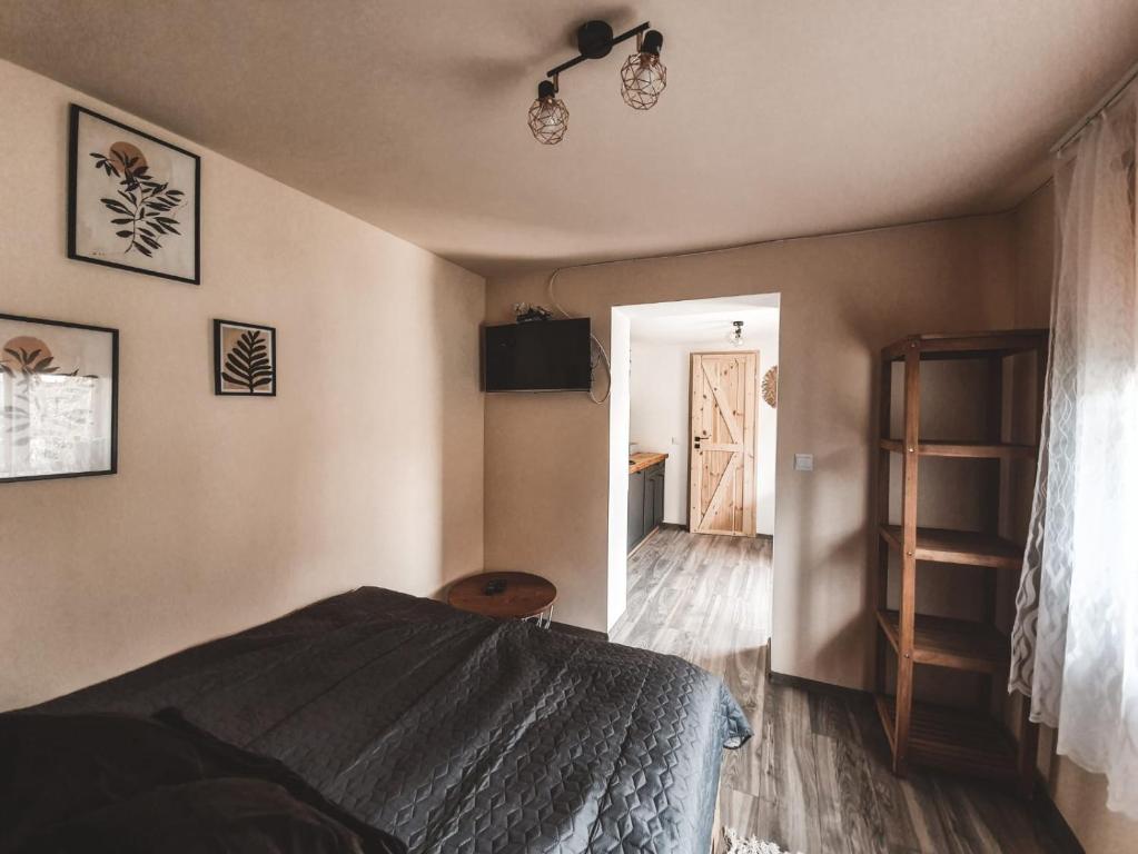a bedroom with a bed and a door to a hallway at Domek pod Lawendą, Roztocze in Rebizanty
