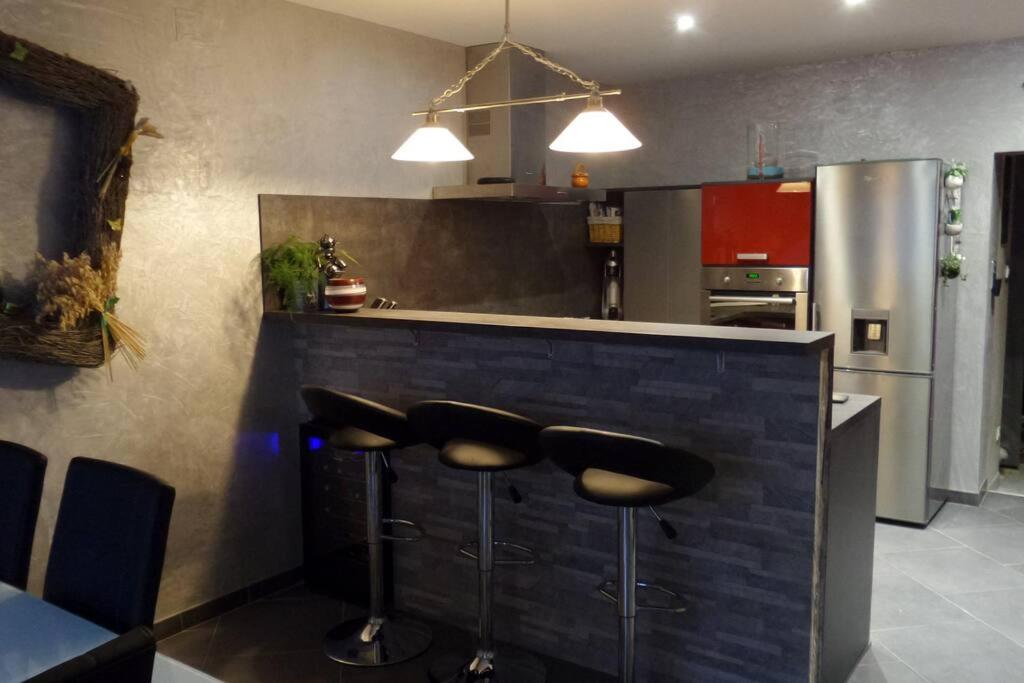 una cocina con encimera con taburetes. en appartement de 70m2 tout équipé, en Hargarten-aux-Mines