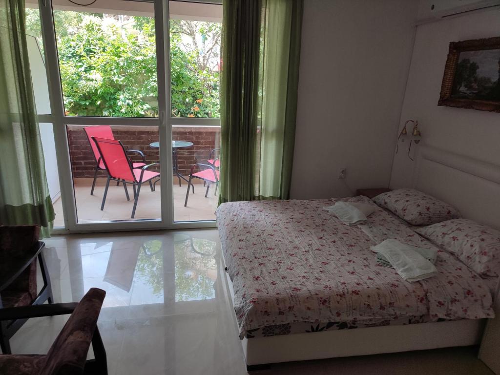 - une chambre avec un lit et un balcon avec des chaises dans l'établissement Apartments Nebojša, à Sokobanja