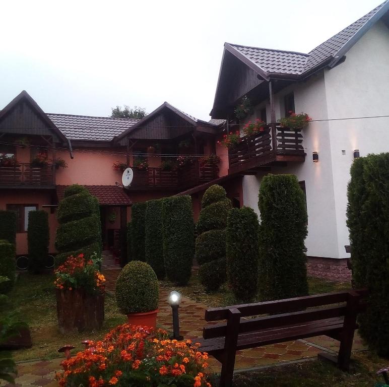 ein Haus mit einer Bank davor in der Unterkunft Pensiunea Denisa in Săcăluşeşti