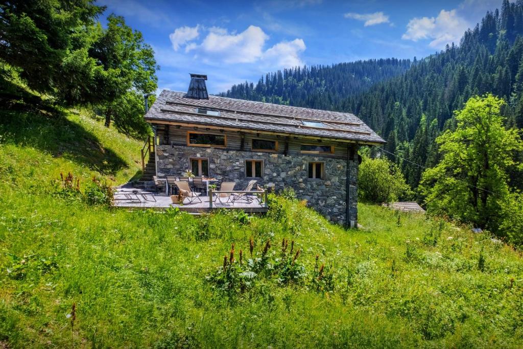 una casa de piedra en una colina en un campo en Chalet Victorina - OVO Network en La Giettaz