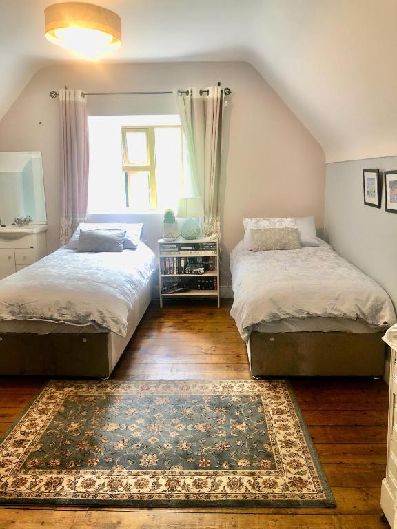 a bedroom with two beds and a rug at Stone Lodge B&B in Balrath