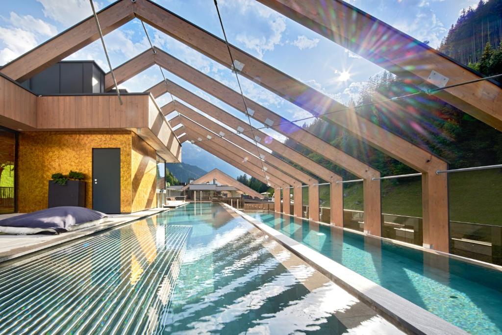 un edificio con piscina con arcobaleno di ZillergrundRock Luxury Mountain Resort a Mayrhofen