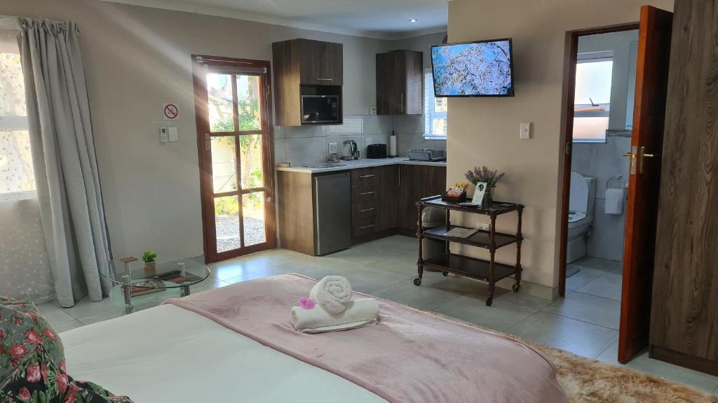 a bedroom with a large bed and a kitchen at Lüneburgh Cottages in East London