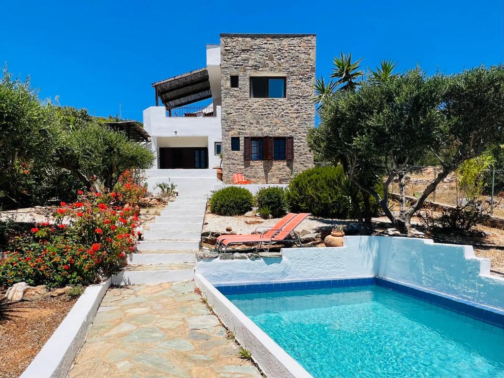 a villa with a swimming pool and a house at Beautiful Villa Helios with stunning sea view! in Vrouhas