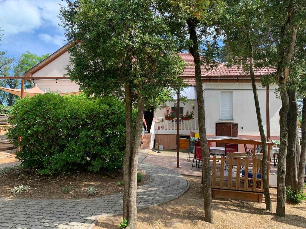 dom ze stołem i drzewami przed nim w obiekcie Edit Villa w Balatonfüred