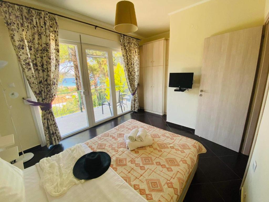 a bedroom with a bed with a hat on it at Villa Vision in Skala Potamias
