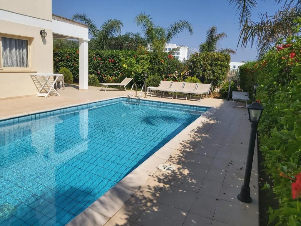 een zwembad in een villa met een resort bij Anthorina Villa 8 in Protaras
