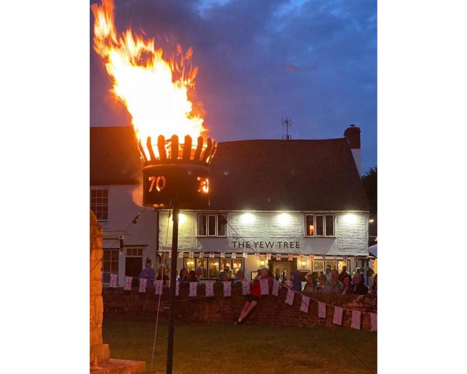 una señal de fuego frente a un edificio con llamas en The Yew Tree, en Manuden