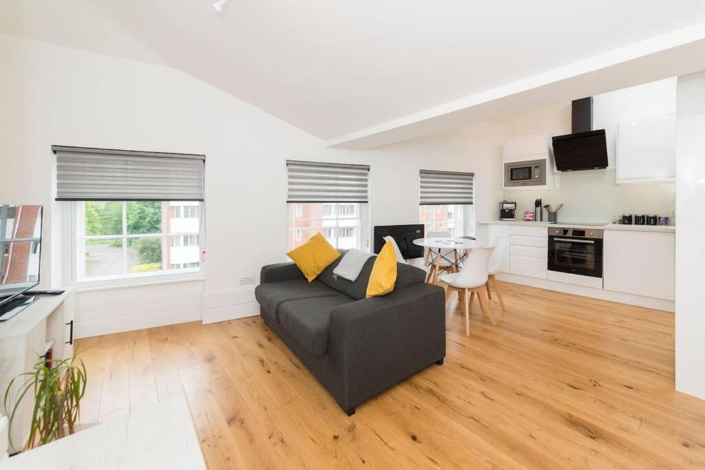 uma sala de estar com um sofá e uma mesa em Lovely 1-BDR w/ free parking in central Reading em Reading