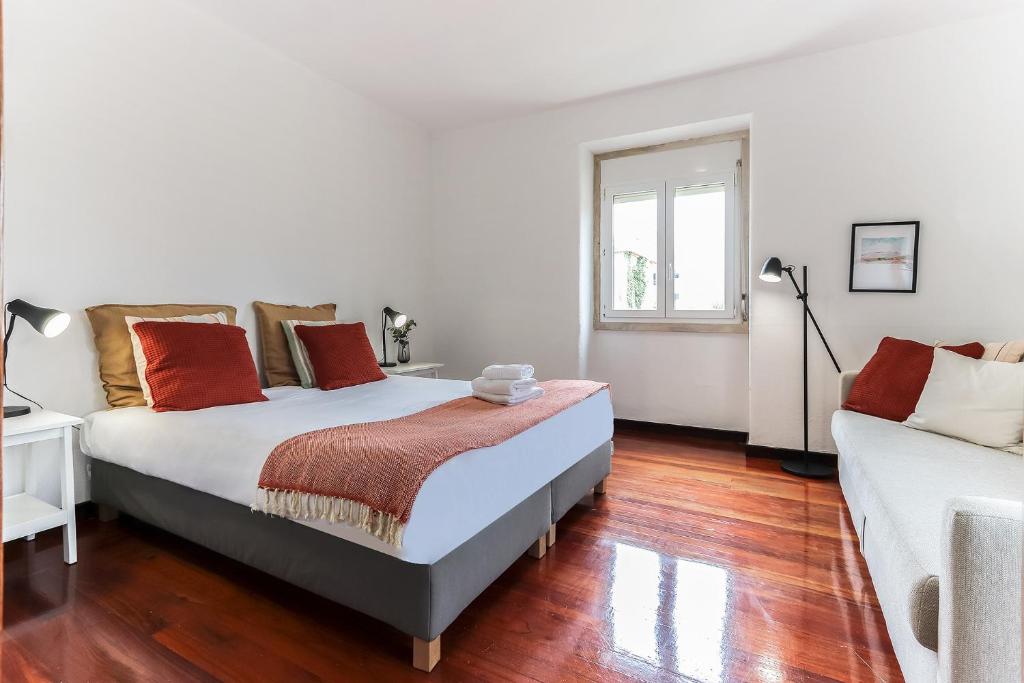 - une chambre avec un lit et un canapé dans l'établissement Belem Boutique Apartments by Homing, à Lisbonne