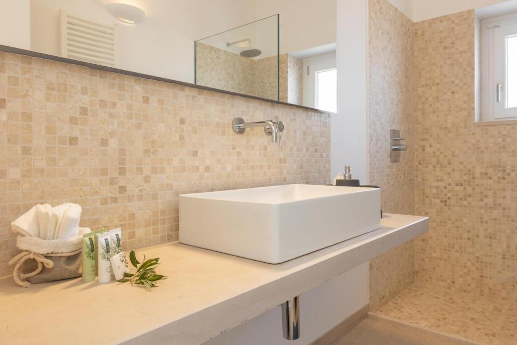 une salle de bains avec un lavabo blanc et un miroir dans l'établissement Villa Panitria, à Ostuni 30 autres photos
