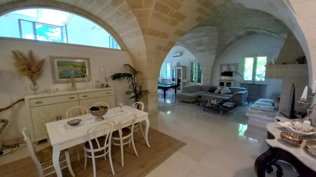 un grand salon avec une table et des chaises dans l'établissement MASSERIA INCANTAMENTO Suite Bouganville, à Latiano