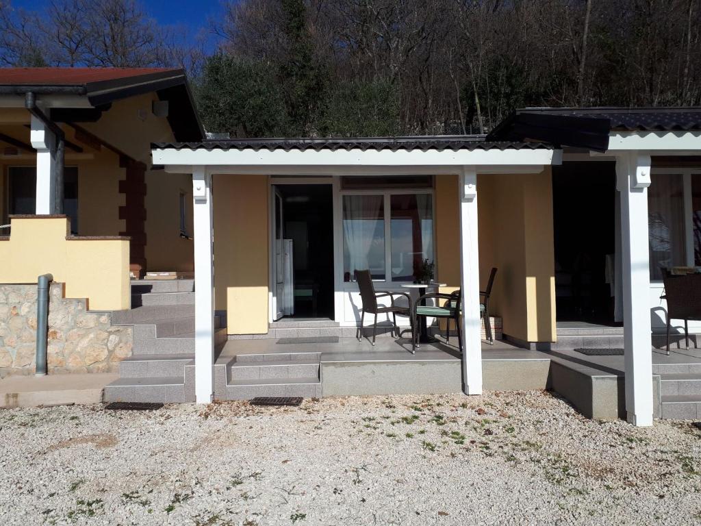 ein Haus mit einer Terrasse mit einem Tisch und Stühlen in der Unterkunft Nice home with private terrace situated near the beach in Tribanj-Krušćica