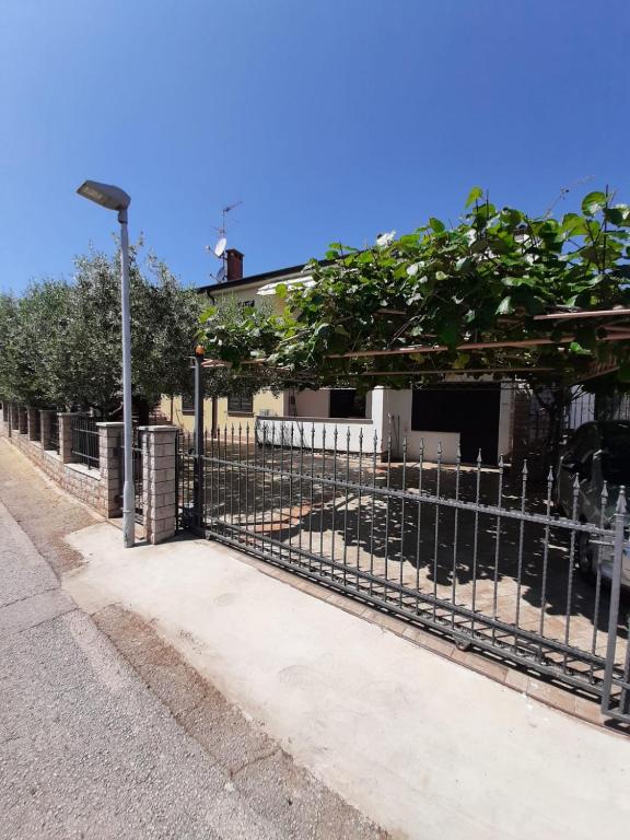 a fence with a light pole next to a house at Norma 3 in Novigrad Istria