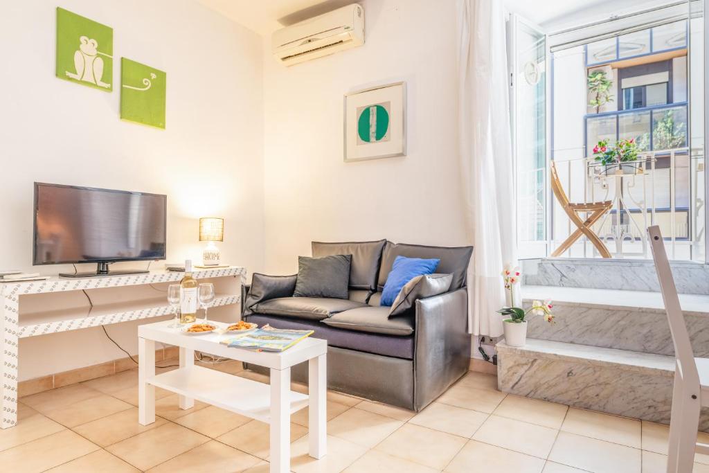ein Wohnzimmer mit einem Sofa und einem TV in der Unterkunft Stazione Centrale & Università Lovely Apartment in Bari