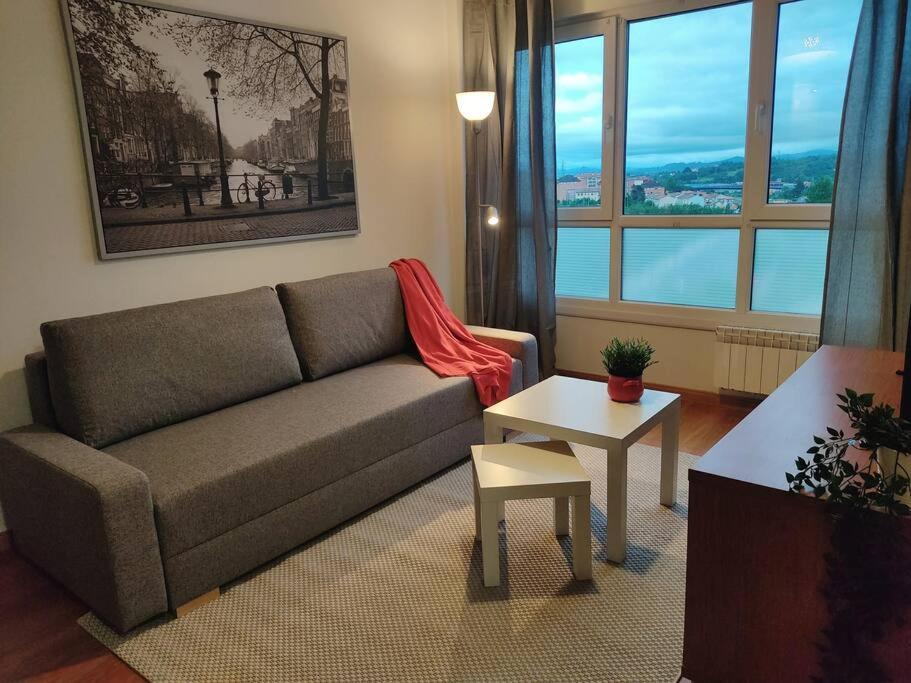sala de estar con sofá y mesa en Apartamento Gloria en Oviedo, en Oviedo