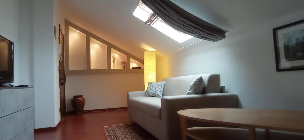 Appartamento mansardato iPatrizi في مونكالييري: غرفة معيشة مع أريكة وطاولة