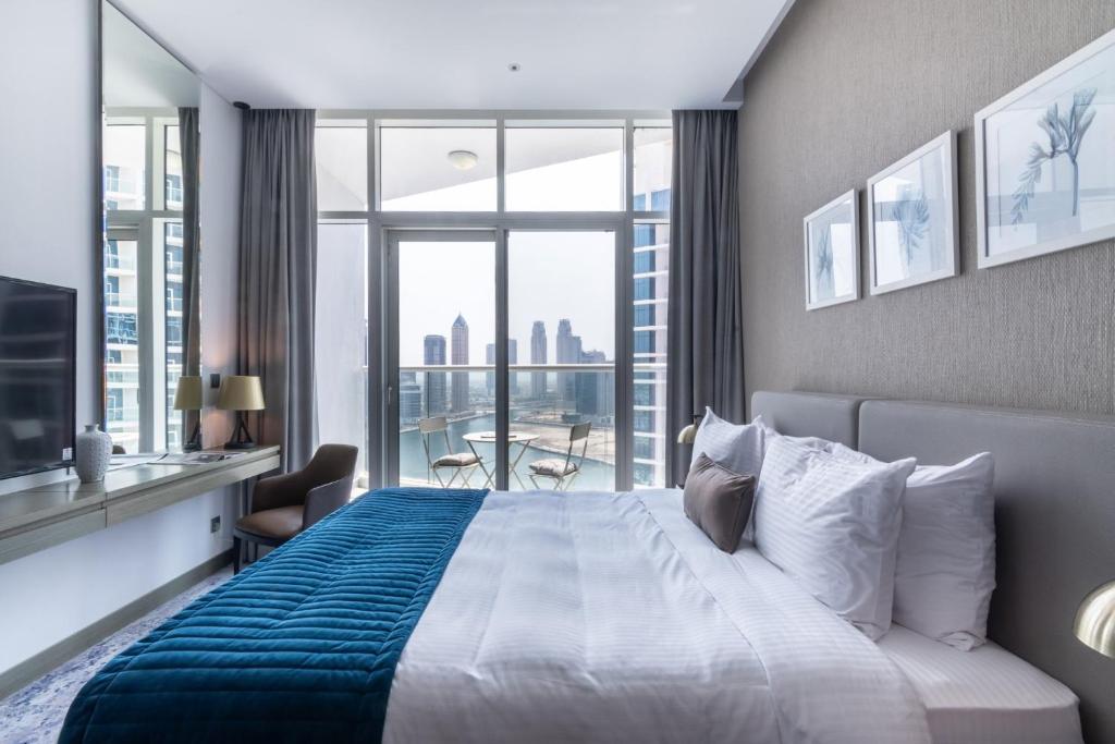 a bedroom with a large bed and a large window at The Smart Concierge - Damac Maison Prive in Dubai