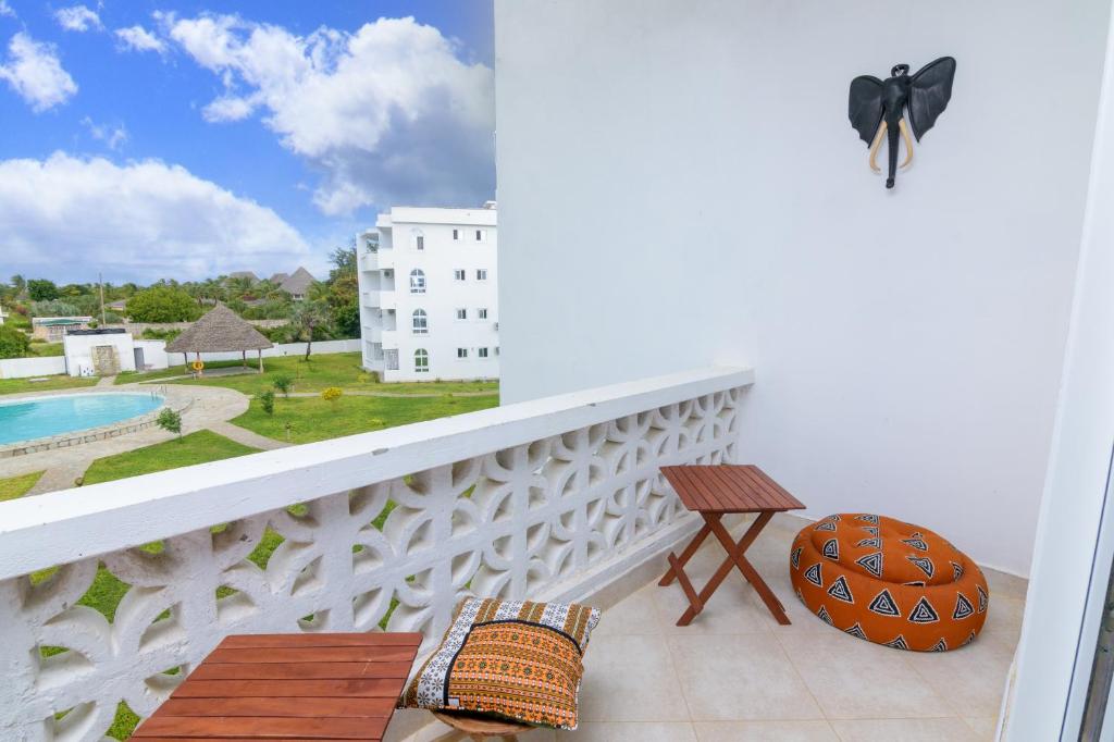 uma varanda com uma mesa e vista para uma piscina em Bali House em Malindi