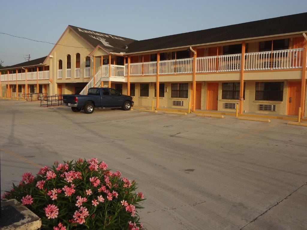 un camión estacionado en un estacionamiento frente a un motel en Antlers Inn Goliad en Goliad