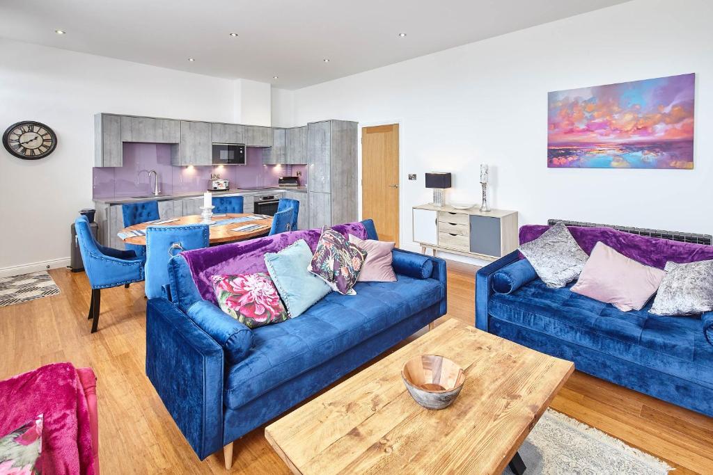 ein Wohnzimmer mit 2 blauen Sofas und einem Tisch in der Unterkunft Host & Stay - Chilton at Carlill House in Whitby