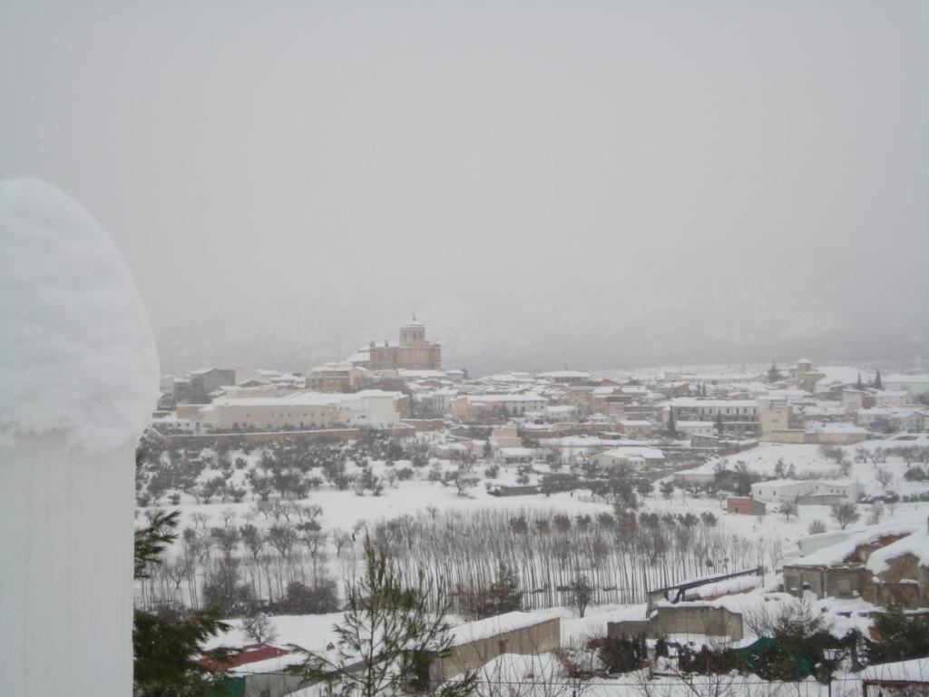 una ciudad cubierta de nieve con una ciudad en el fondo en Cueva de La Alegría, en Huéscar