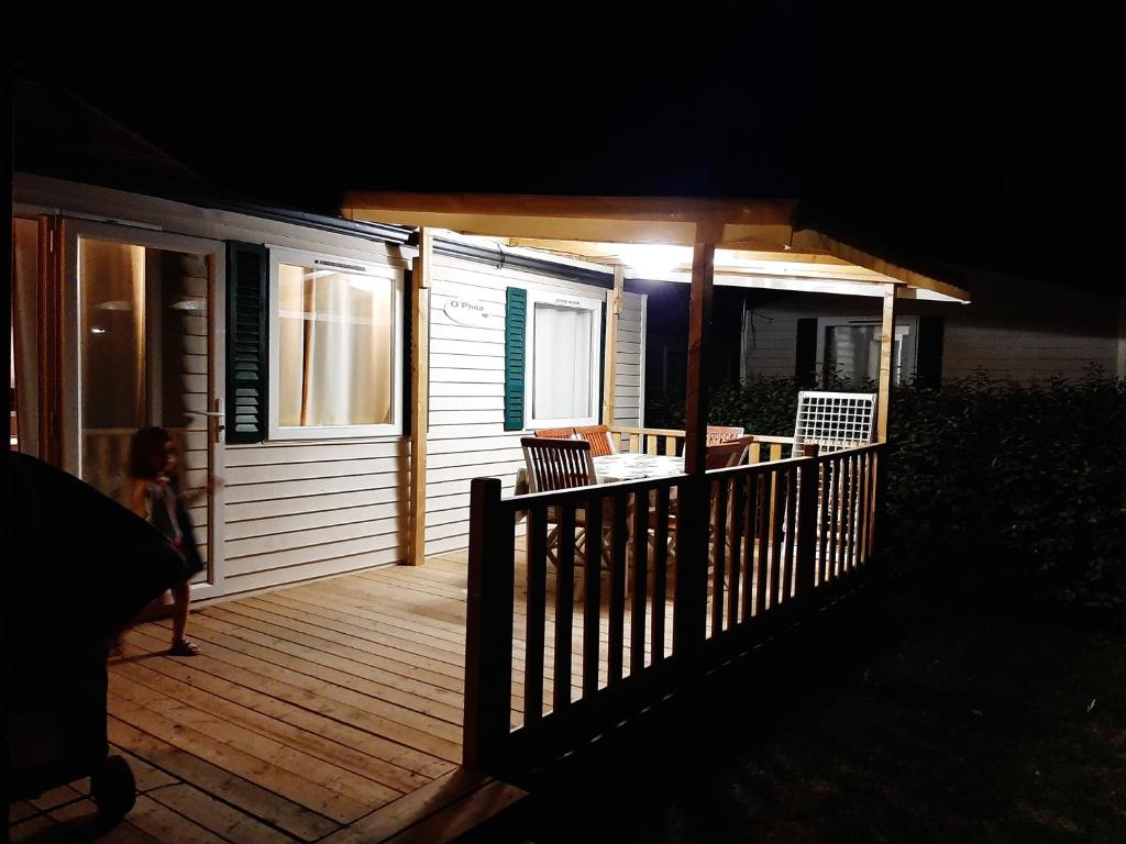 un porche con terraza de madera por la noche en mobile home entierement équipé, en La Roque-d'Anthéron