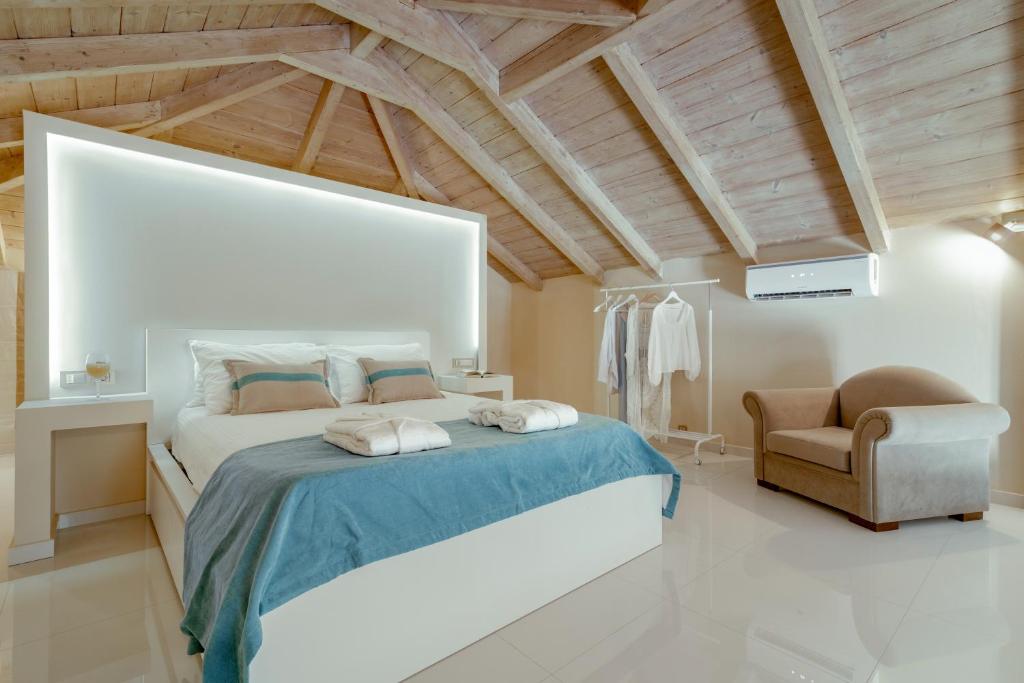 a bedroom with a large bed and a chair at Chryssi Akti Family Villa and Studios in Argassi