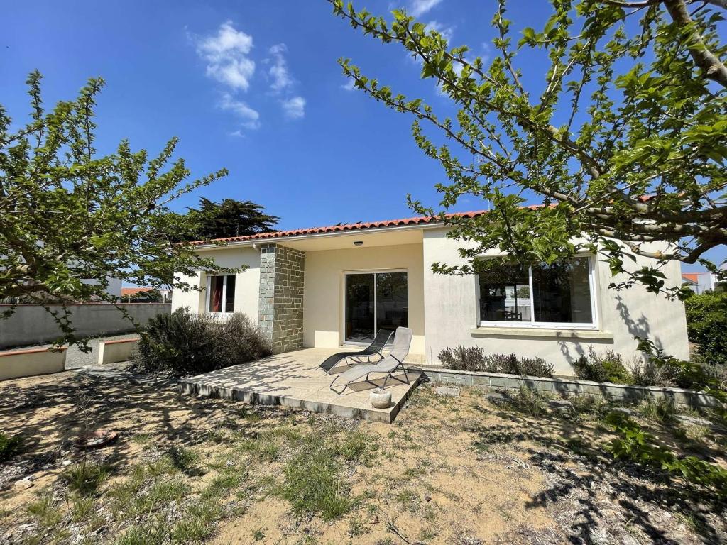 un banc installé sur une terrasse devant une maison dans l'établissement Maison de vacances 3 chambres près mer, jardin, terrasse, wifi, calme, 6 couchages - Bretignolles - FR-1-224A-19, à Bretignolles-sur-Mer